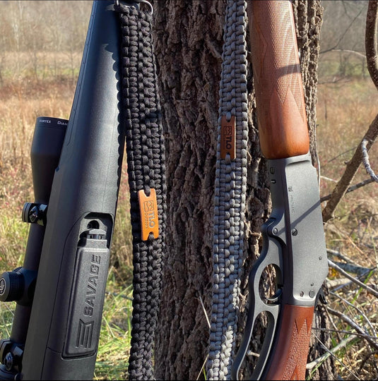 tlo outdoors black and gray paracord gun slings on rifles leaning against tree